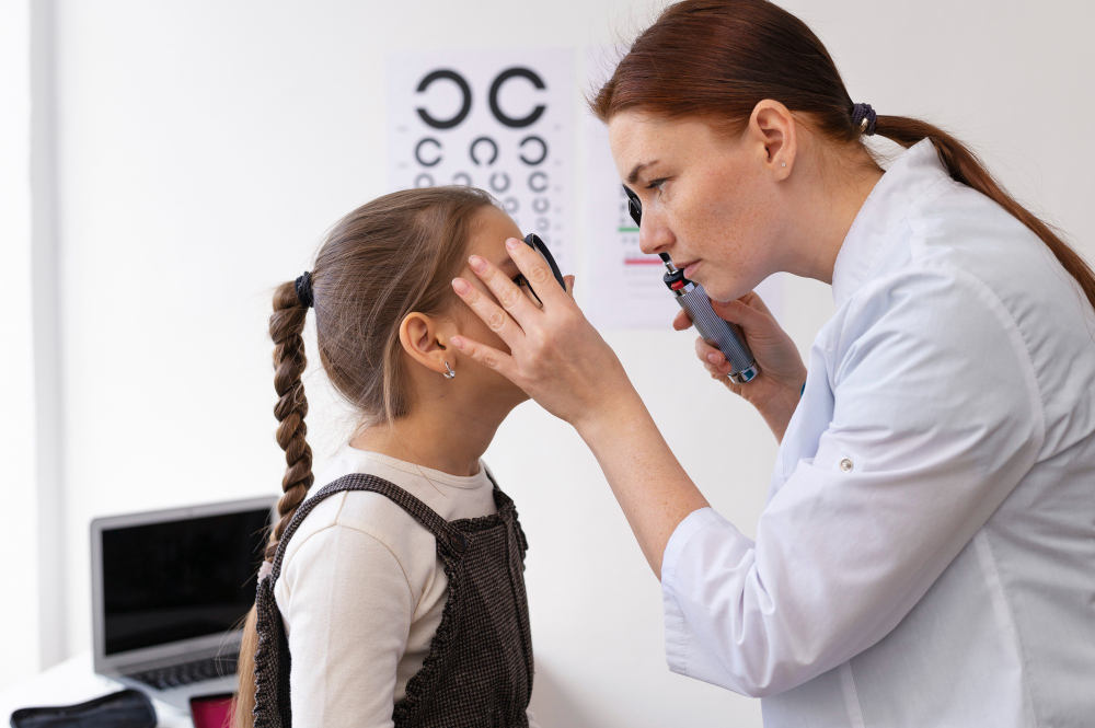 Specialist checking a child's eyes with an eye chart during a vision therapy evaluation