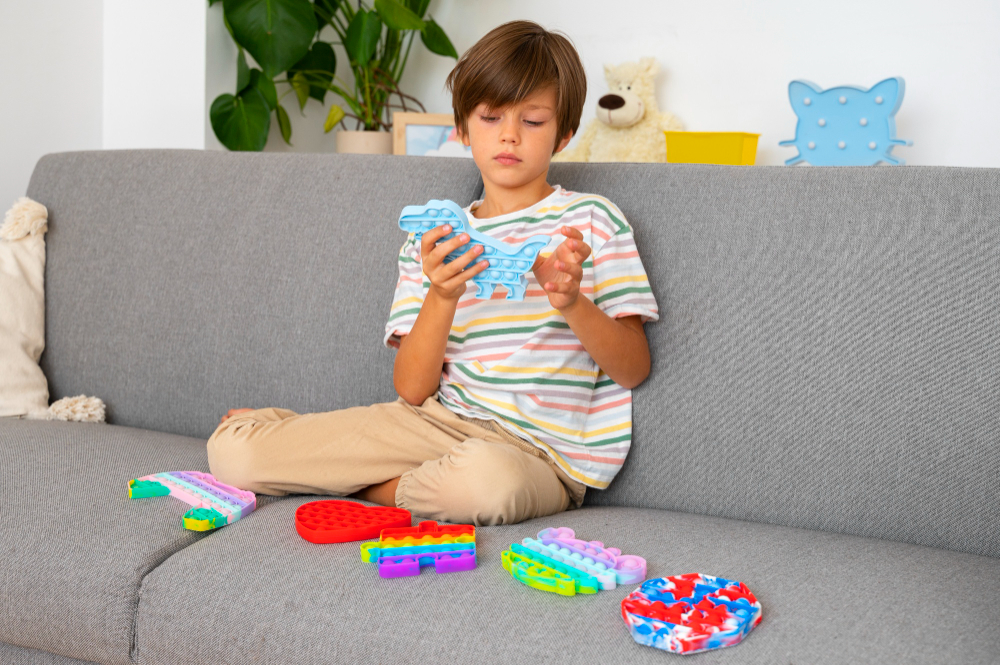 Boy playing with colorful sensory fidget toys on a couch